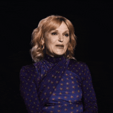 a woman with red hair is wearing a purple shirt with stars on it