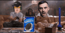 a box of oreo cookies sits on a table next to a man playing a video game