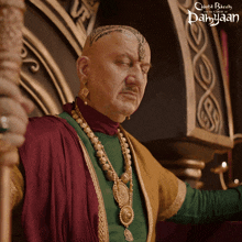 a poster for a movie called damyaan shows a bald man in a green robe