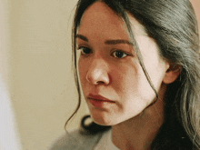 a close up of a woman 's face with long dark hair