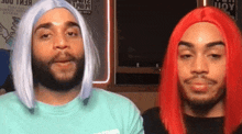 two men wearing wigs are standing next to each other in front of a sign that says ' people ' on it