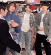 a group of young men are standing next to each other and dancing in a room .