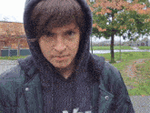a young man wearing a hooded jacket and a black sweatshirt with the letter n on it