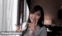 a woman is sitting in front of a window with her hands in the air .