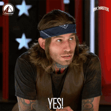 a man wearing a bandana on his head and a black shirt says yes