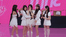 a group of girls are standing in front of a pink background with a sign that says ' music '