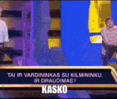 a man is sitting at a table with a sign that says kasko on it