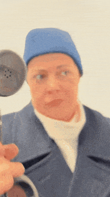 a woman in a blue hat is holding a stethoscope in front of her face