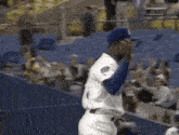 a baseball player with the number 1 on his jersey stands in front of a crowd .