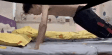 a man is doing push ups on a bed in a room .