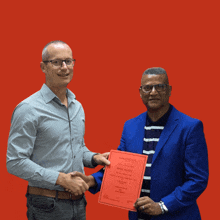 two men shaking hands in front of a red background that says mastered