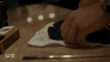 a person is cleaning a gun with a towel on a table with a usa logo in the corner .