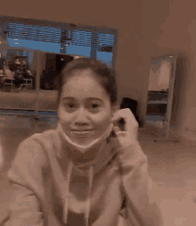 a blurry picture of a woman wearing a mask in a living room .