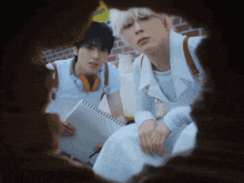 two young men are looking through a hole in the wall