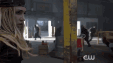 a group of people are standing next to each other in a room with a cw logo on the bottom .