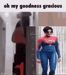 a woman in a superman costume is walking down the street .