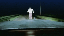 a man is running down a dark road at night
