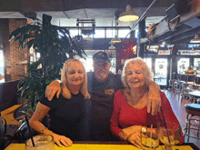 a man wearing a shirt that says ' stump ' on it poses for a picture with two women