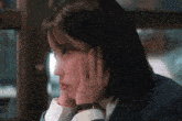 a woman with a watch on her wrist is looking out a window