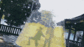 a giant glass filled with a yellow liquid with a reflection of two people