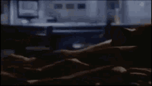 a blurry picture of a man and woman laying on a bed in a dark room .