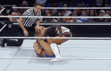 two women are wrestling in a ring with a referee and a smackdown logo
