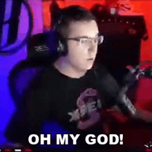 a man wearing glasses and headphones is sitting in front of a microphone and saying `` oh my god '' .