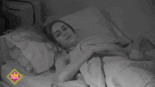 a black and white photo of a woman laying in bed with a sign in the background that says ' segundo piso '