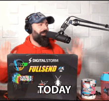 a man speaking into a microphone behind a laptop that says digital storm fullsend today