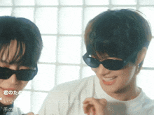 two men wearing sunglasses are smiling in front of a window with the words dancing dancing below them