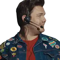 a man wearing a headset and a denim jacket with stickers on it