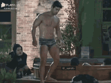 a man without a shirt is standing in front of a hot tub ..