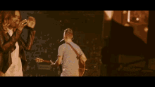 a man singing into a microphone while holding a guitar