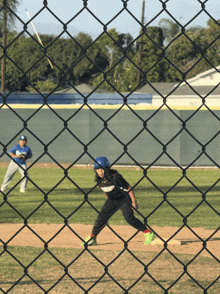 a baseball game is being played behind a chain link fence with a player wearing a jersey that says ' la '