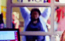 a blurry picture of a person standing in front of a window with a globe logo on it .