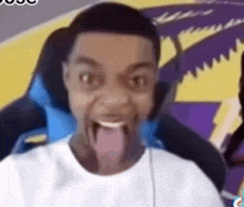 a man is sitting in a chair with his tongue out and making a funny face .