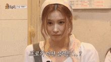 a woman wearing a head scarf and a white shirt is talking to someone .