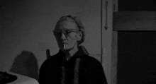 a black and white photo of an elderly woman smoking a cigarette .