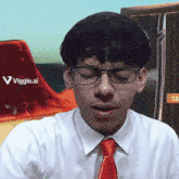 a man wearing glasses and a red tie has a viggle.ai sticker on his shirt