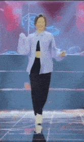 a woman is dancing on a stage in front of a blue background .