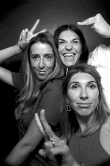 three women are posing for a picture and one of them is wearing a wedding ring