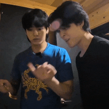 two men are standing next to each other and one of them is wearing a blue shirt that says salt to the sore