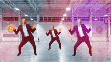 three men in suits are dancing in a warehouse with a bitcoin symbol in the background