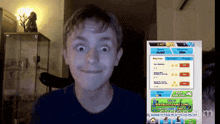 a boy is making a funny face while playing a video game