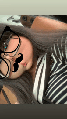 a woman wearing glasses and a fake mustache on her face