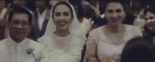 a bride and groom are walking down the aisle at a wedding ceremony with their parents .
