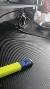a yellow and blue lighter is sitting on a black table
