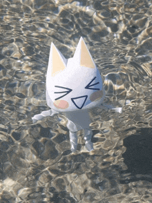 a white cat with a yellow ear is floating in a body of water
