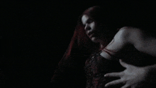 a woman with red hair is being touched in the dark