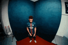 a man in a qatar jersey stands in a corner of a room